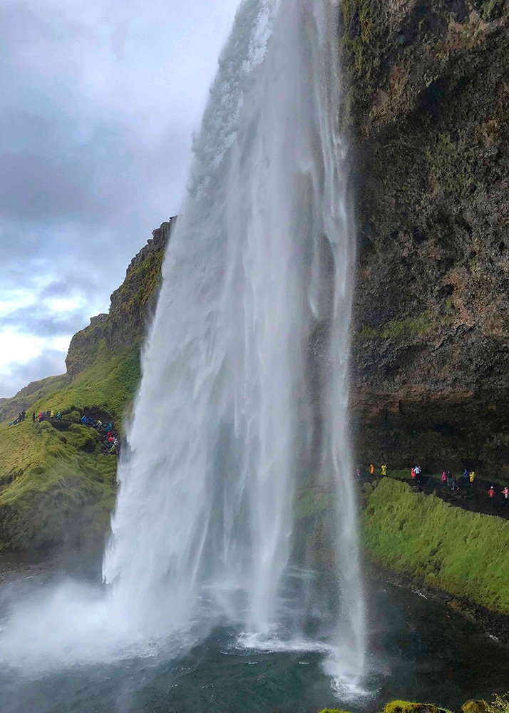 Close-up view of the powerful Seljalandsfoss waterfall in Iceland, with a walkway behind the falling water.