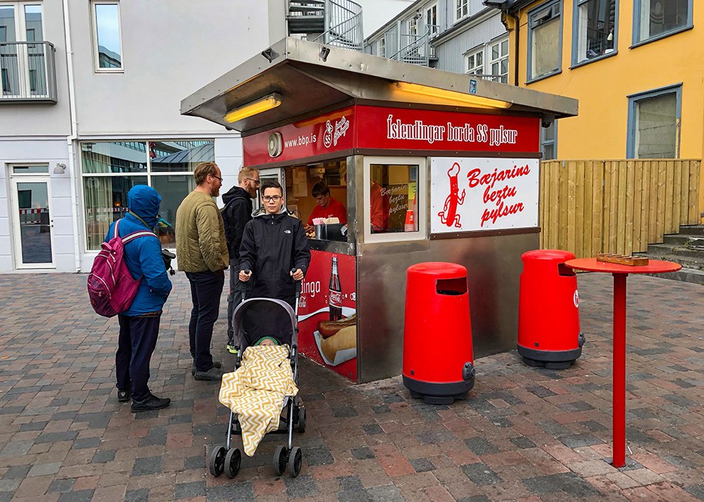 People standing in line at the famous Bæjarins Beztu Pylsur hot dog stand in Reykjavik, Iceland.