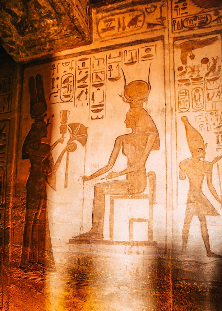 Interior of Nefertari Temple adorned with intricate wall carvings and hieroglyphics depicting ancient Egyptian deities and scenes.