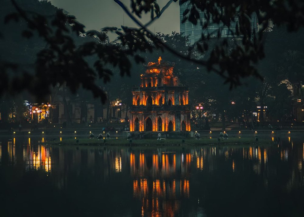 View of the Hoan Kiem Lake in Hanoi at night - Vietnam: A nighttime view of the serene Hoan Kiem Lake, reflecting city lights.