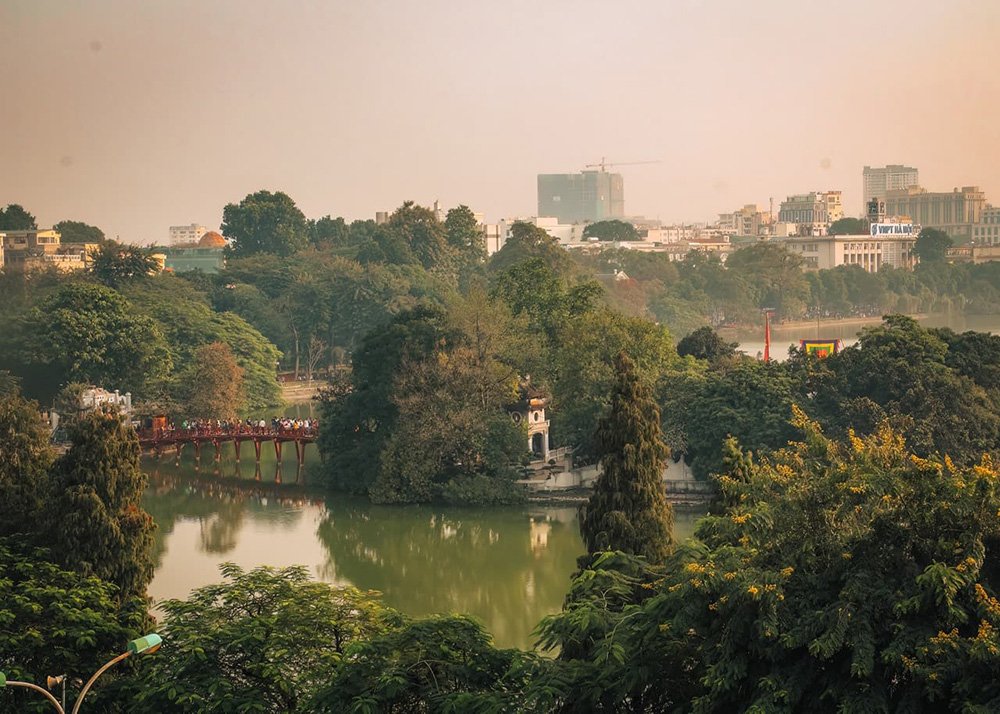 Hoan Kiem Lake in Hanoi - Vietnam: A picturesque view of Hoan Kiem Lake during the day with lush greenery.