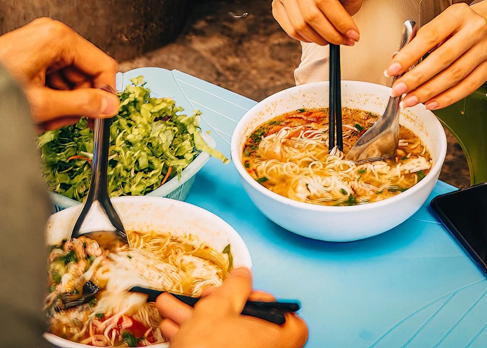 Pho is a popular soup that you can get from street stalls in the Old Quarter of Hanoi in Vietnam: A steaming bowl of Pho, a traditional Vietnamese soup, served at a street stall.
