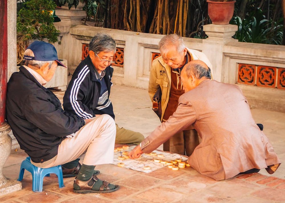 Vietnamese men playing a game at Ngoc Son Temple in Hanoi - Vietnam: A group of Vietnamese men engaged in a traditional game at Ngoc Son Temple in Hanoi.