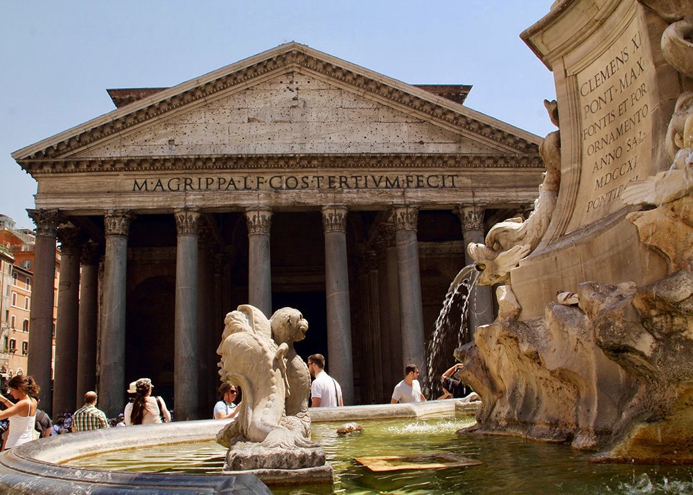 Pantheon in Rome: The majestic Pantheon in Rome with its grand columns and intricate fountain in the foreground, surrounded by tourists admiring the ancient architecture.