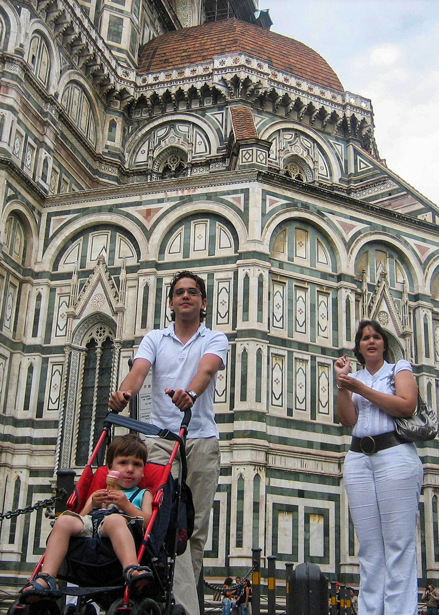 A close-up of Il Duomo in Florence with a man behind a stroller with a boy and a woman next to him