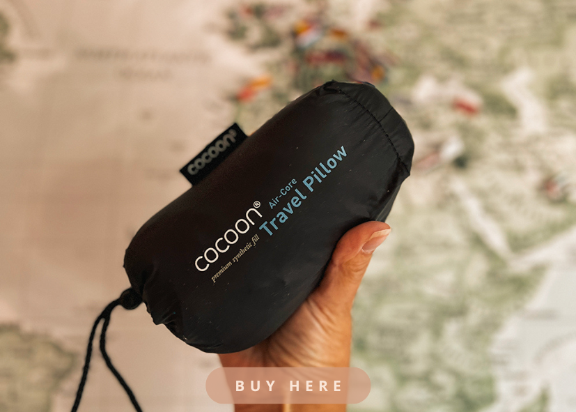 Link to the homepage of Cocoon USA, pictured is a hand holding a travel pillow from the brand Cocoon USA.