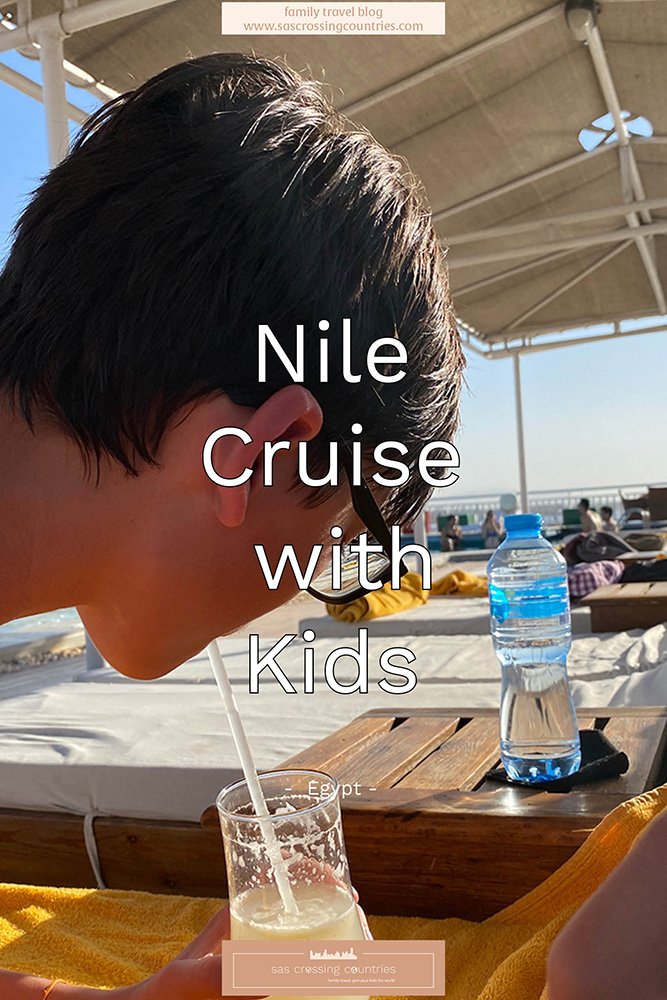 Cover image for a family travel blog post titled "Nile Cruise with Kids," showcasing a a teen lying on a sunbed sipping from a lemon juice in a cocktail glass enjoying the view of the Nile river. The blog URL "www.sascrossingcountries.com" is visible at the top.