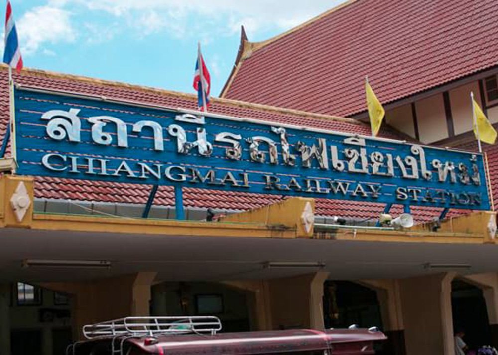 The entrance of Chiang Mai Railway Station, featuring a sign in both Thai and English script.