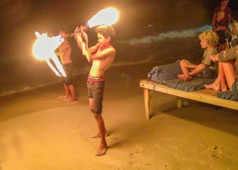 Children performing a fire show on the beach at night in Koh Samet, Thailand.