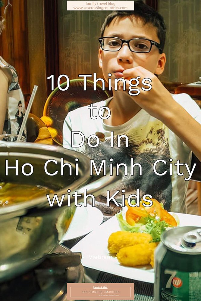 Cover image for a family travel blog post titled "10 things to do in Ho Chi Minh City with kids" showcasing a boy eating a spring roll with a large hot pot in front of him and a plate with spring rolls and a 7up. The blog URL "www.sascrossingcountries.com" is visible at the top.