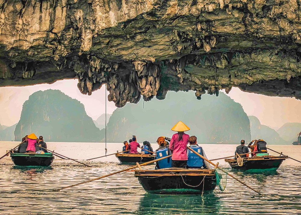 On a rowing boat in Halong Bay, Vietnam: A family enjoys a scenic boat ride among limestone karsts in Halong Bay, Vietnam.
