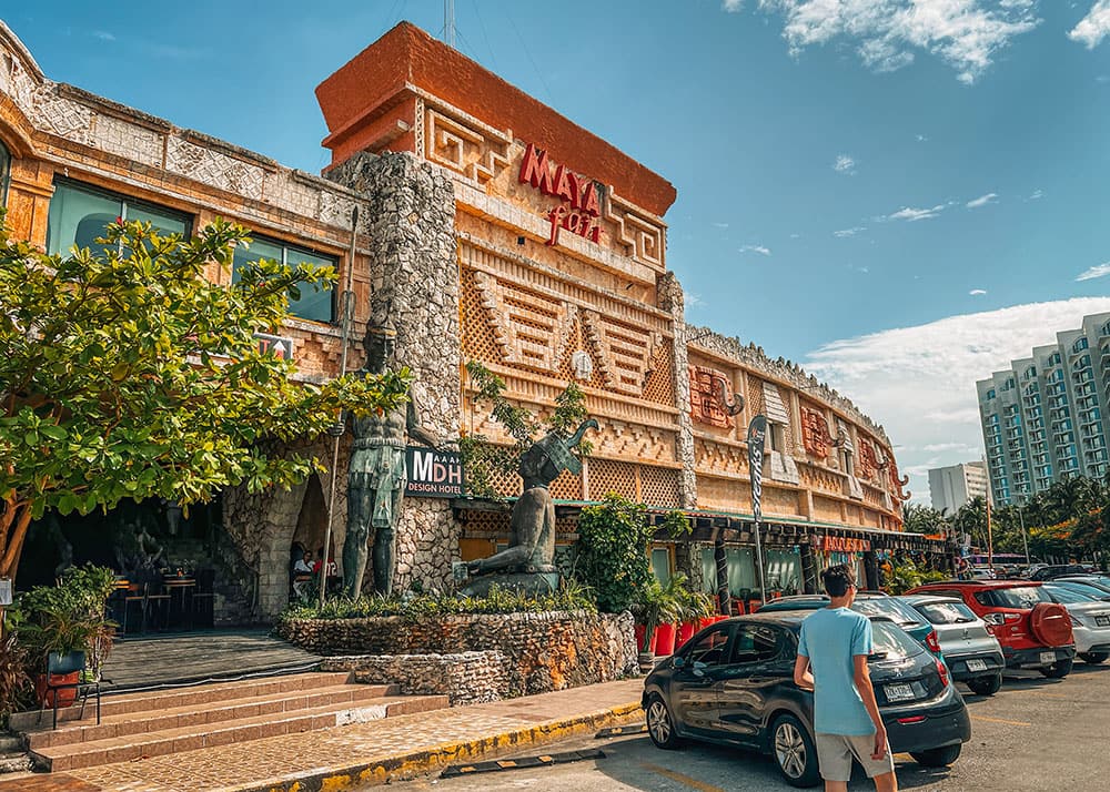 A parking lot in Cancun with in the background a huge restaurant. The facade gives a maya inspired feel.