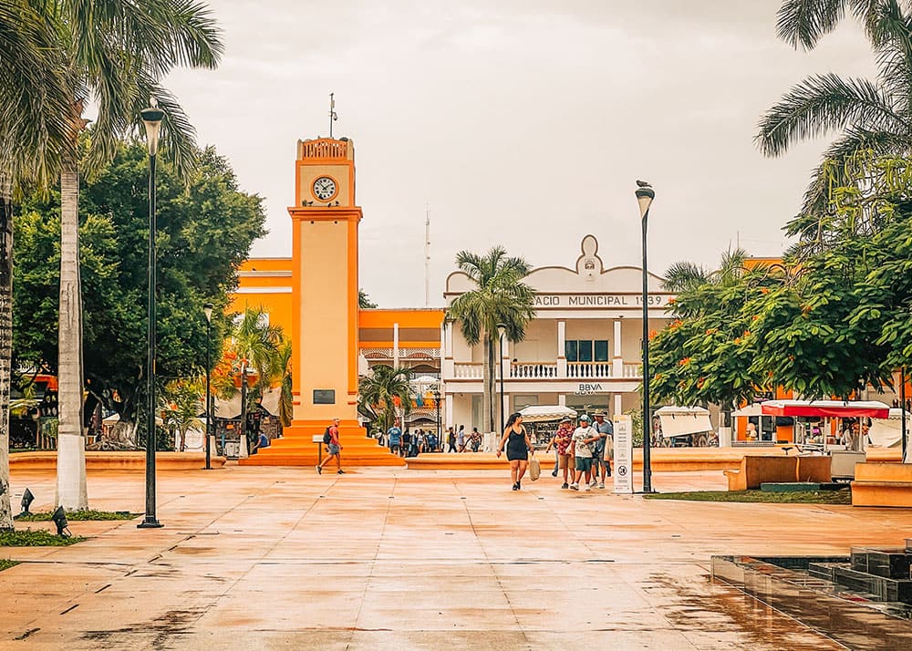 The bustling Central Plaza in Cozumel, Mexico, with vibrant shops, restaurants, and local vendors. The sunny weather and colorful surroundings create a lively and welcoming atmosphere for visitors.