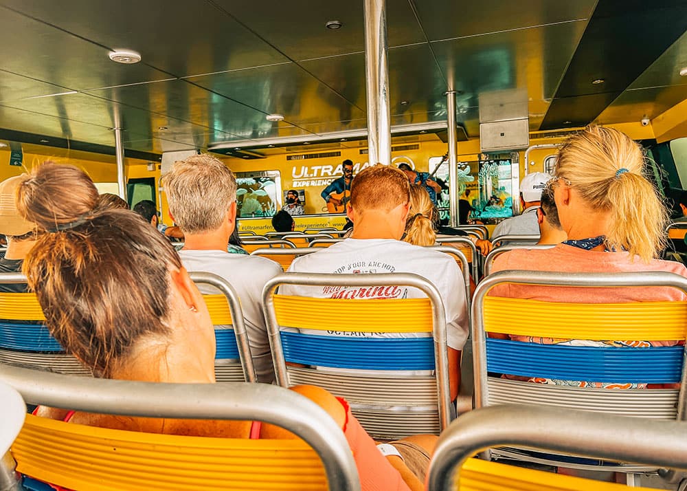 Passengers on a ferry ride from Playa Del Carmen to Cozumel island, Mexico, enjoying the scenic views of the Caribbean Sea. The weather is clear, and the blue waters create a stunning backdrop for the journey.