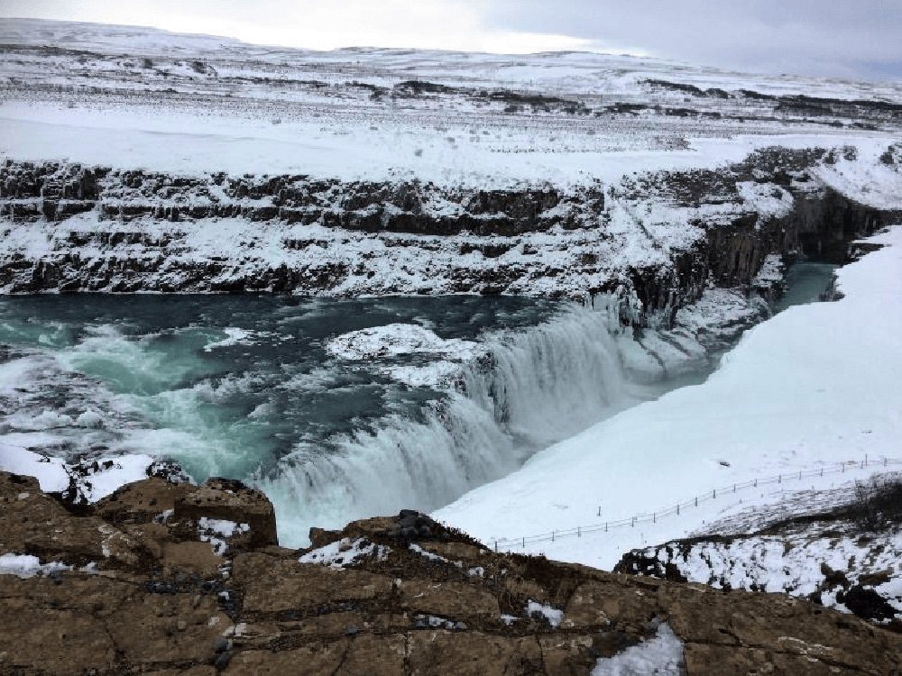 Gullfoss waterfall in winter. Snow is all around and ice can be seen in the distance