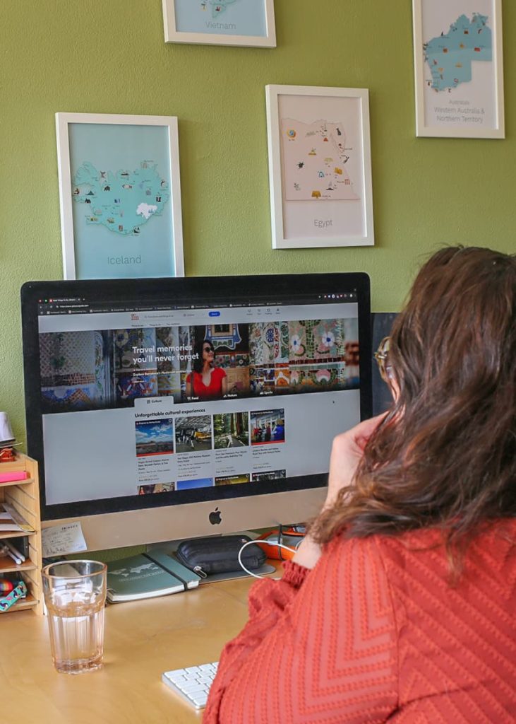 a picture of a woman behind a desktop with the Get Your Guide website open with different ticket options on the screen