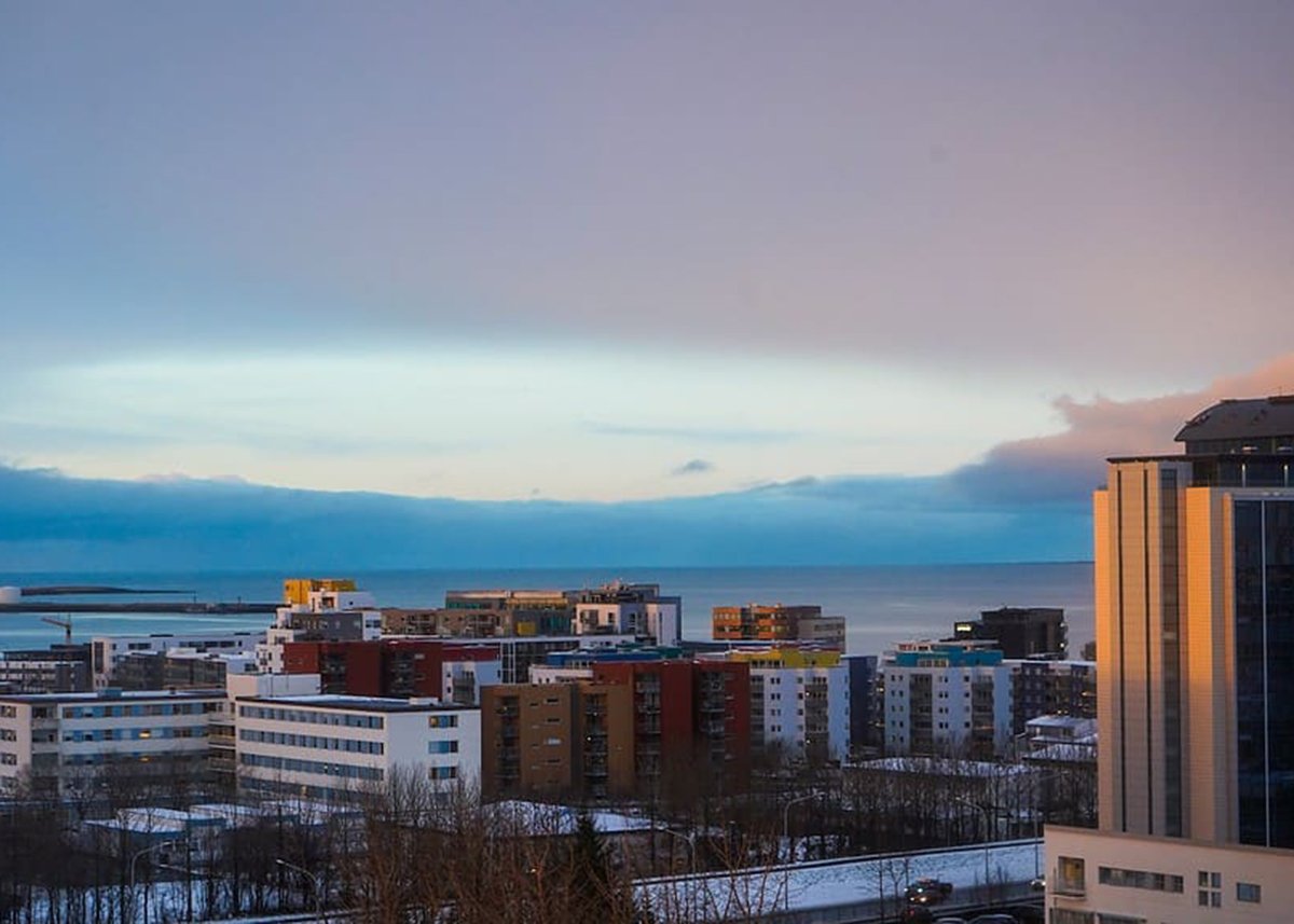 The skyline of Reykjavik at sunset snow can be seen on rooftops and on the side of the roads