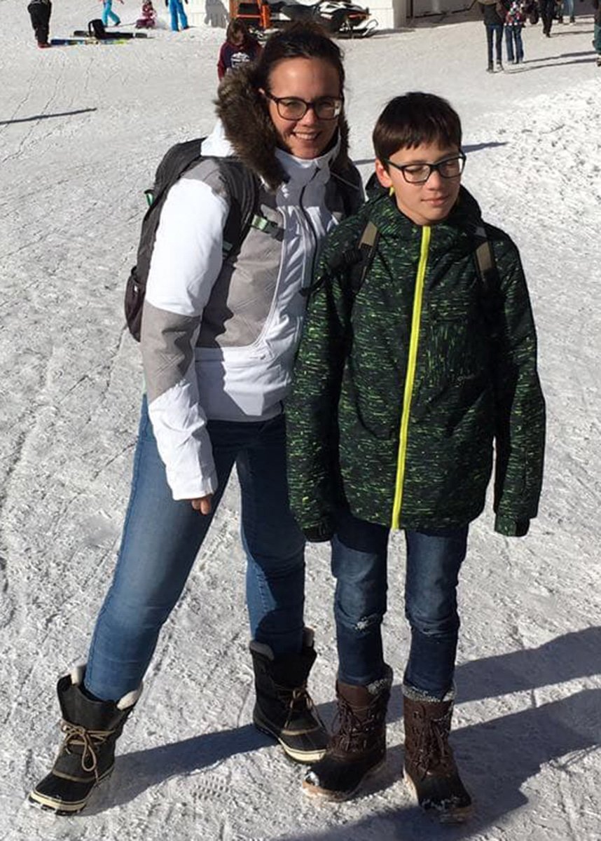 A mother and son in the snow wearing warm clothes