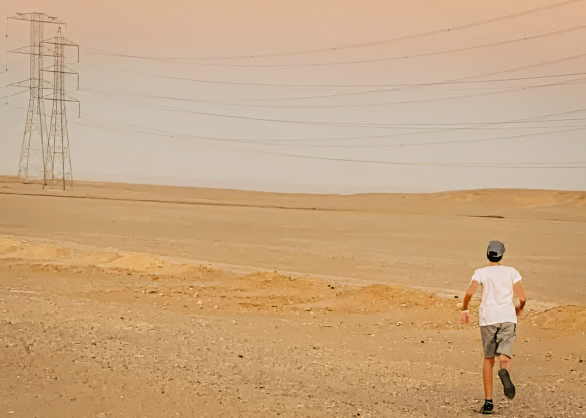 Teen is running through the desert next to the road from Aswan to Abu Simbel, stretching his legs a bit