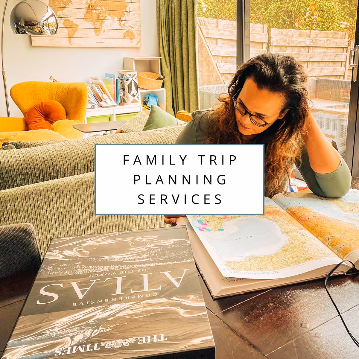 Clickable photo of a woman browsing through a big atlas that lies on table. Clicking this photo leads to a page where you can find info about all family travel planning services from Sas Crossing Countries.