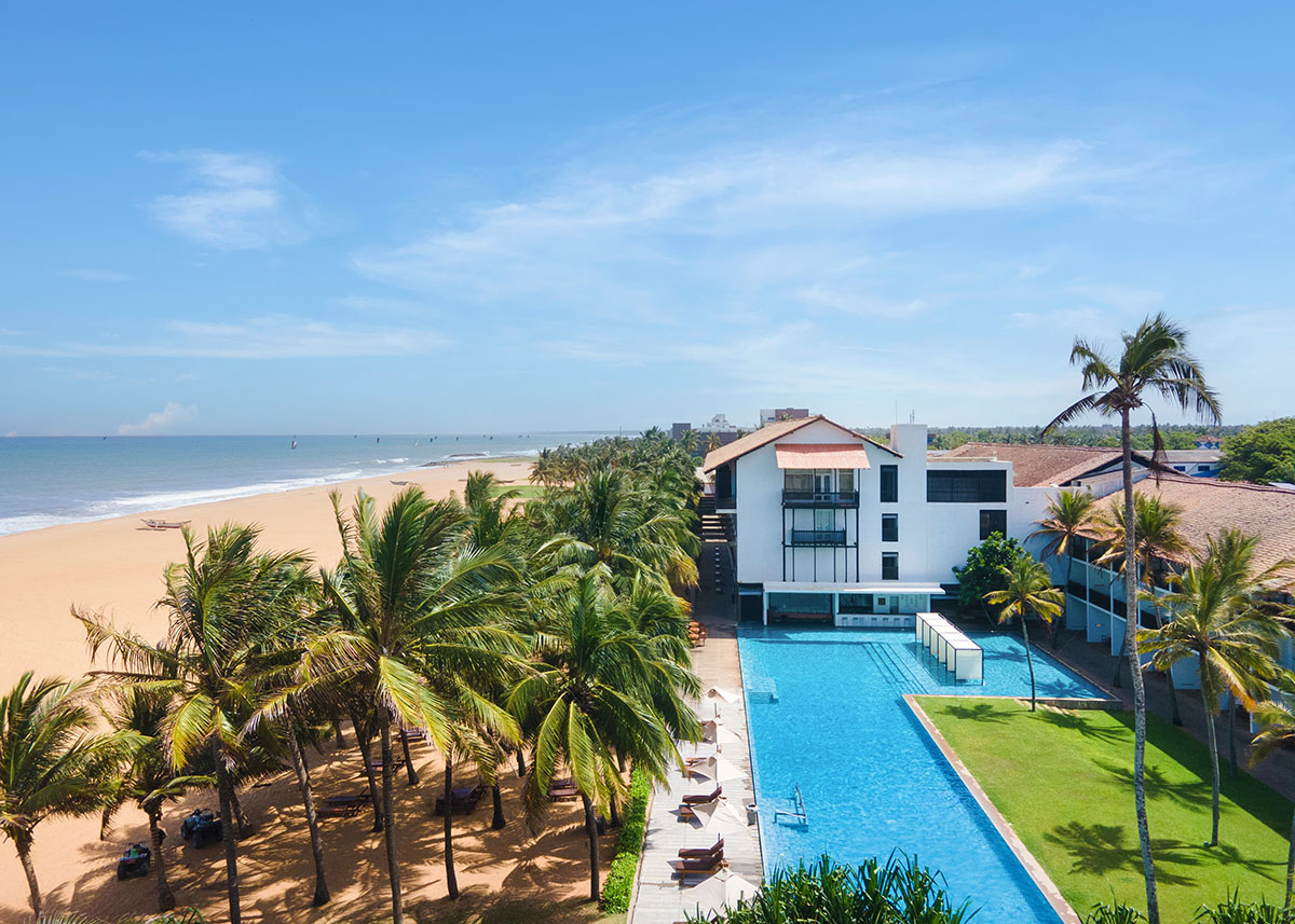 The exterior of Jetwing Blue in Negombo with the pool and beach in front of it.