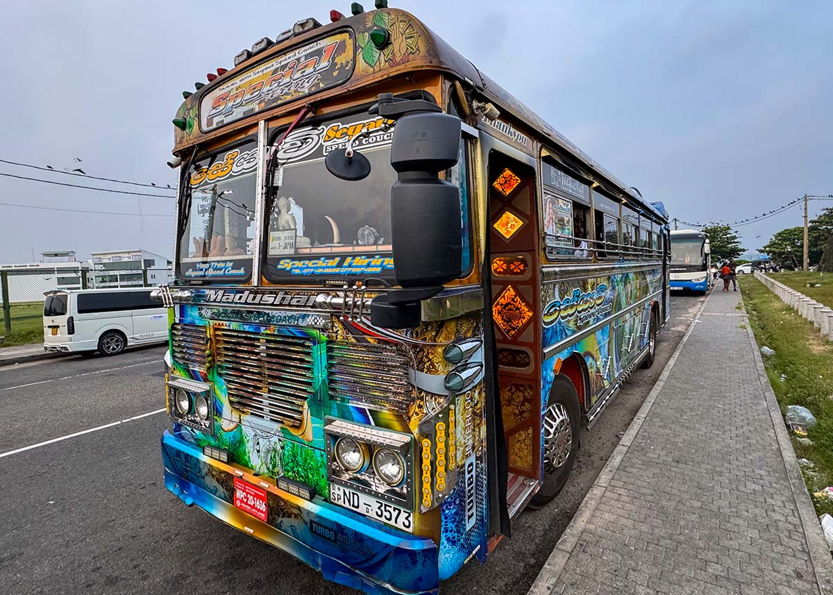 Colorful decorated Sri Lankan bus parked roadside in Negombo with bold designs and signage.