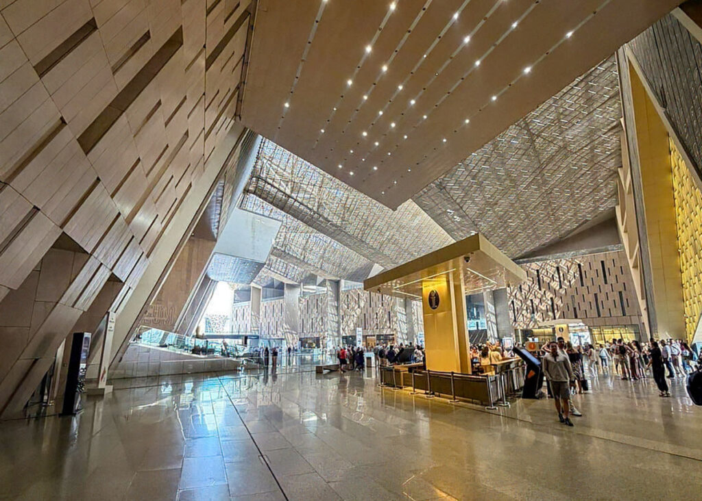 The entrance hall of the Grand Egyptian Museum filled with dozens of people.